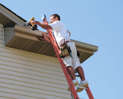 RainMaster-seamless-gutters man attaching new gutter system - Rain Master Seamless Gutters