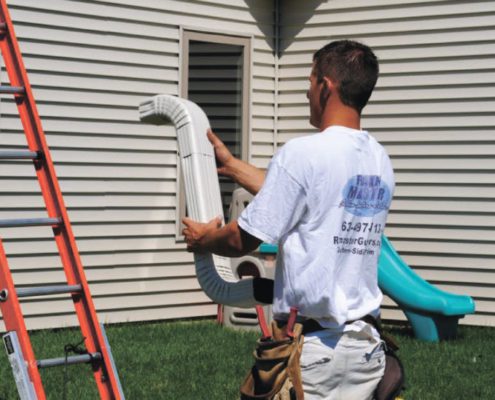 RainMaster-seamless-gutters man examining gutter prior to installation - Rain Master Seamless Gutters