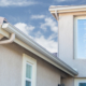 close up of a stucco home with white rain gutters - Rain Master Seamless Gutters