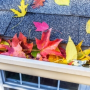 house roof with fall leaves in the gutters - Rain Master fall gutter prep