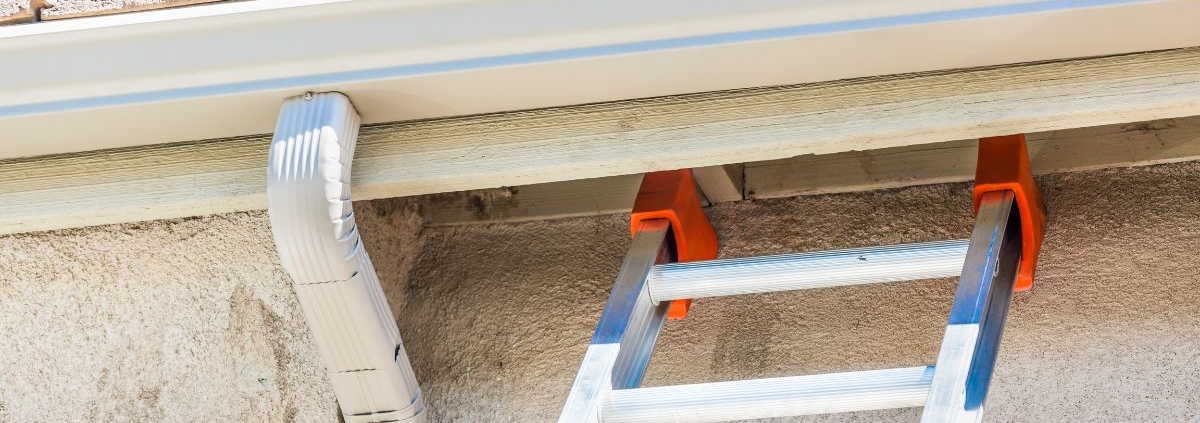 white seamless gutters with a metal ladder - Rain Master Seamless Gutters