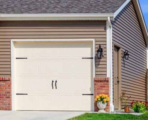 house with a white garage door with black accents - Rain Master seamless gutter installation near Clearwater