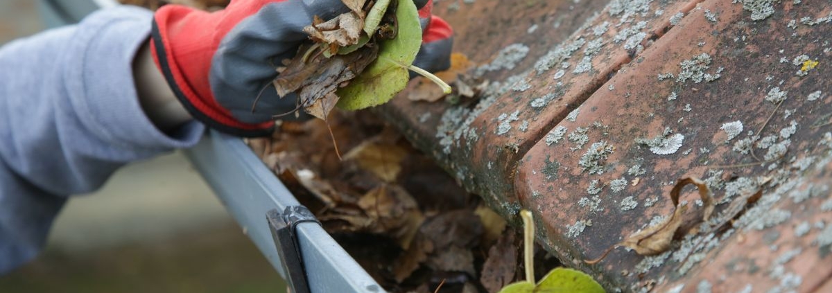 person wearing gloves cleaning gutters - Rain Master gutter cleaning