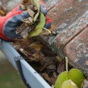 person wearing gloves cleaning gutters - Rain Master gutter cleaning