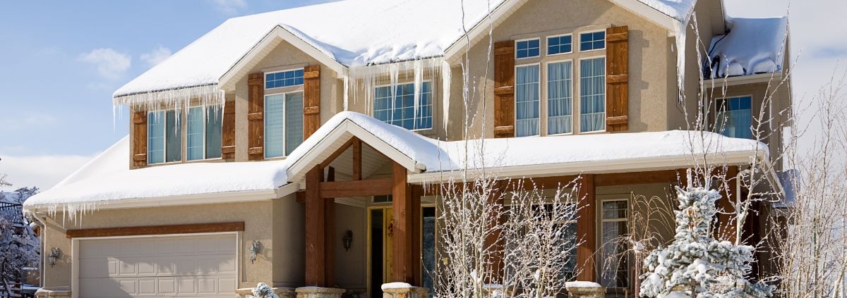 house with snow on roof and large icicles - Rain Master seamless gutters