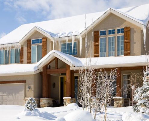 house with snow on roof and large icicles - Rain Master seamless gutters