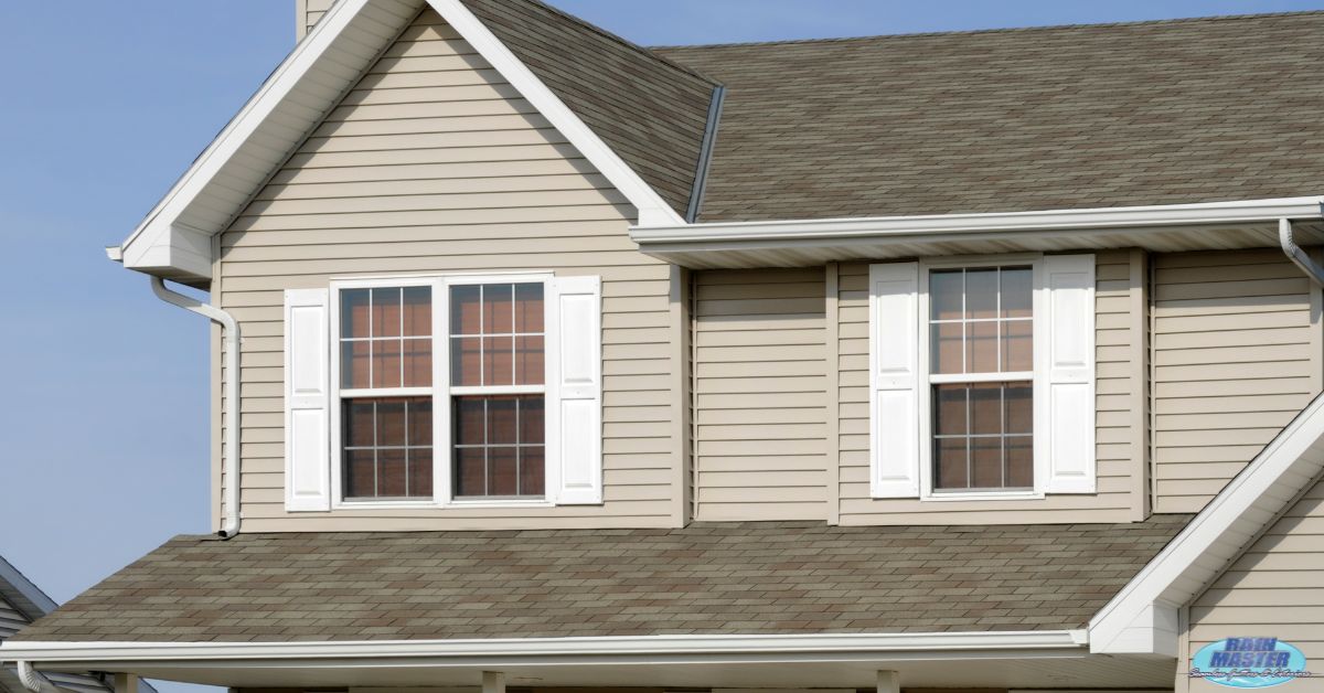 house with light brown siding and white shutters - Rain Master seamless gutters
