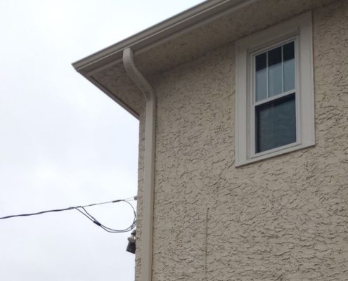 house with stucco siding - Rain Master seamless gutter installation near Anoka