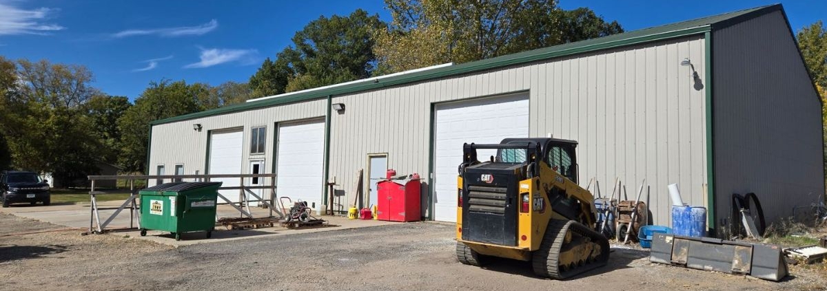 commercial building with three white garage doors - Rain Master commercial gutter installation