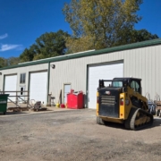 commercial building with three white garage doors - Rain Master commercial gutter installation