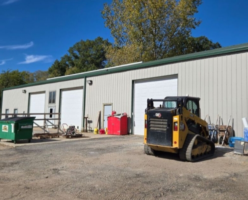 commercial building with three white garage doors - Rain Master commercial gutter installation