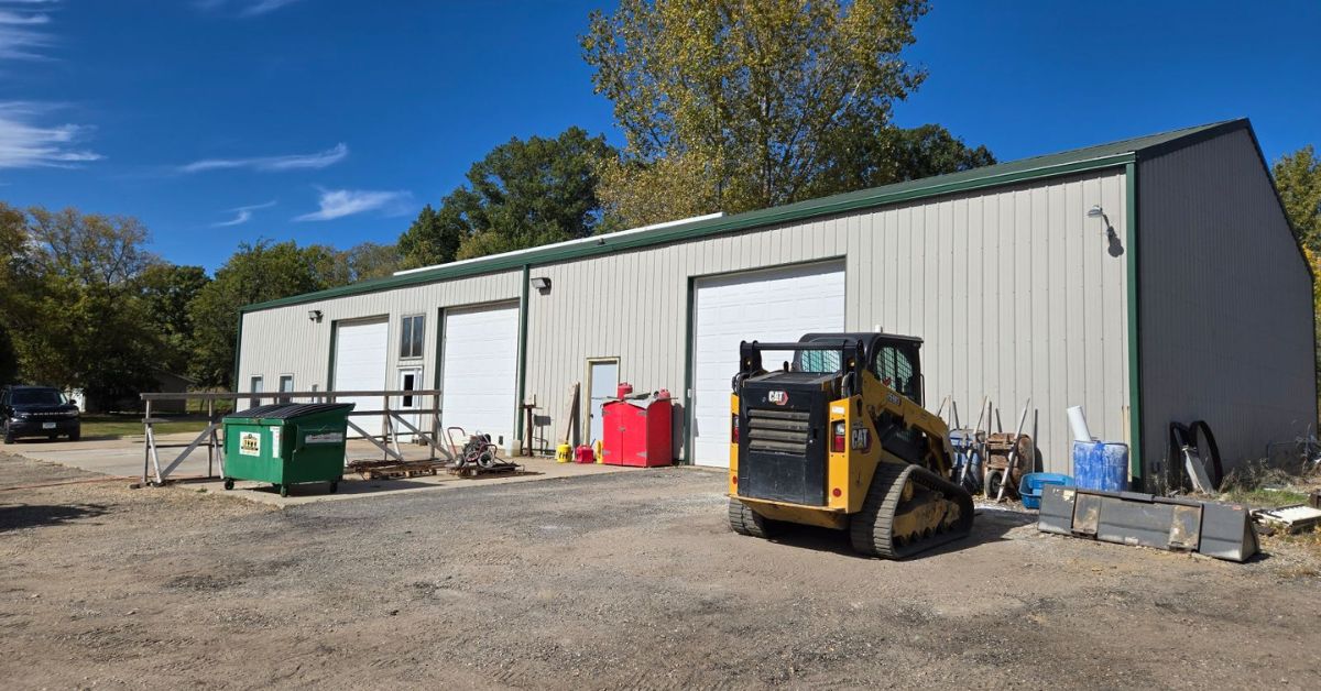 commercial building with three white garage doors - Rain Master gutter replacement