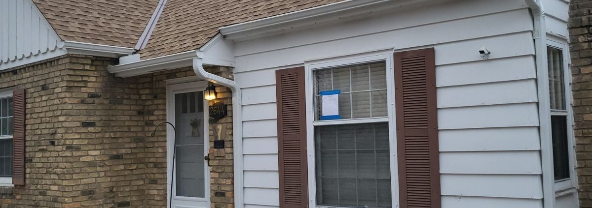 house with brown roof and brown shutters - Rain Master seamless gutters