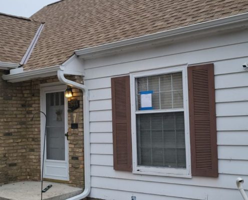 house with brown roof and brown shutters - Rain Master seamless gutters