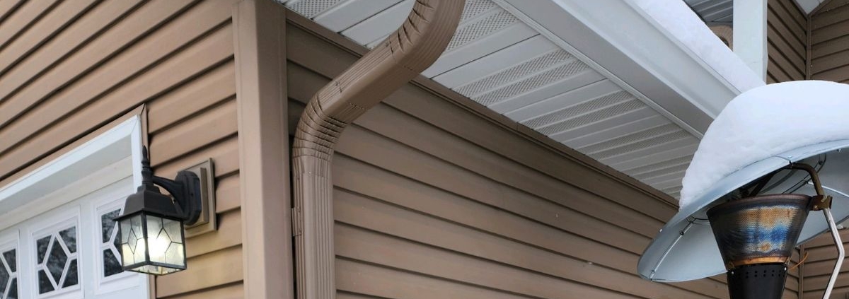 house with mustard colored siding and seamless gutters - Rain Master seamless gutters