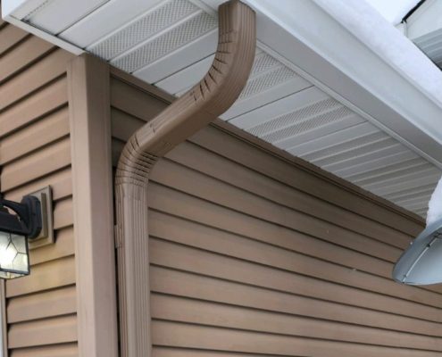 house with mustard colored siding and seamless gutters - Rain Master seamless gutters