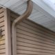 house with mustard colored siding and seamless gutters - Rain Master seamless gutters
