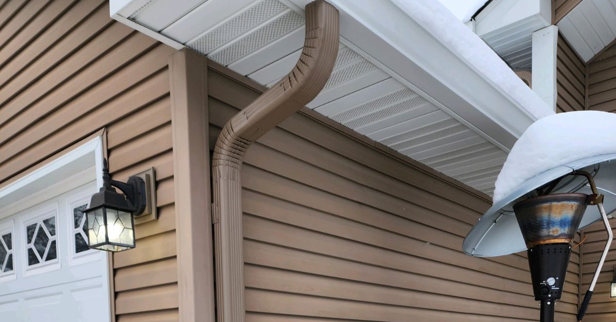 house with mustard colored siding and seamless gutters - Rain Master seamless gutters