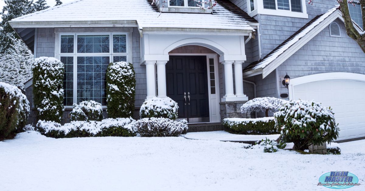 exterior of a blue home in the winter - Rain Master seamless gutters