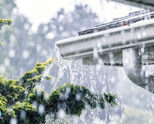 pouring rain with a focus on white gutters - Rain Master Seamless Gutters Gutter installers near St. Paul