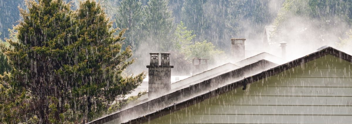 exterior of home roof during a rain storm - Rain Master gutters for drainage
