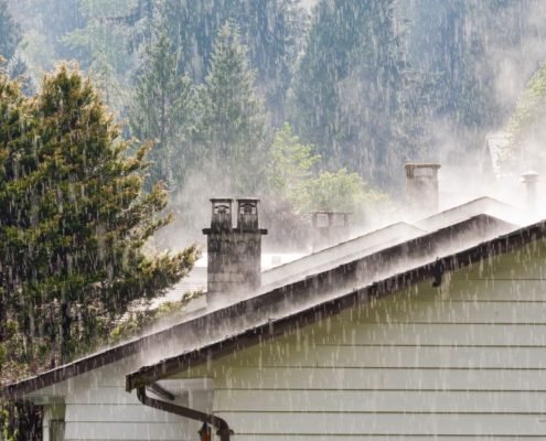 exterior of home roof during a rain storm - Rain Master Gutter installers near St. Paul