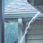 exterior of home roof during a rain storm - Rain Master seamless gutters Can Clogged Gutters Lead to Foundation Damage?