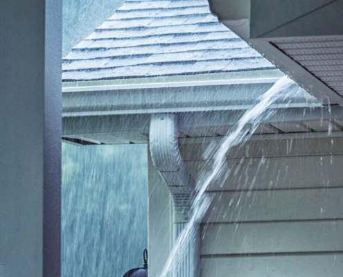 exterior of home roof during a rain storm - Rain Master seamless gutters Can Clogged Gutters Lead to Foundation Damage?