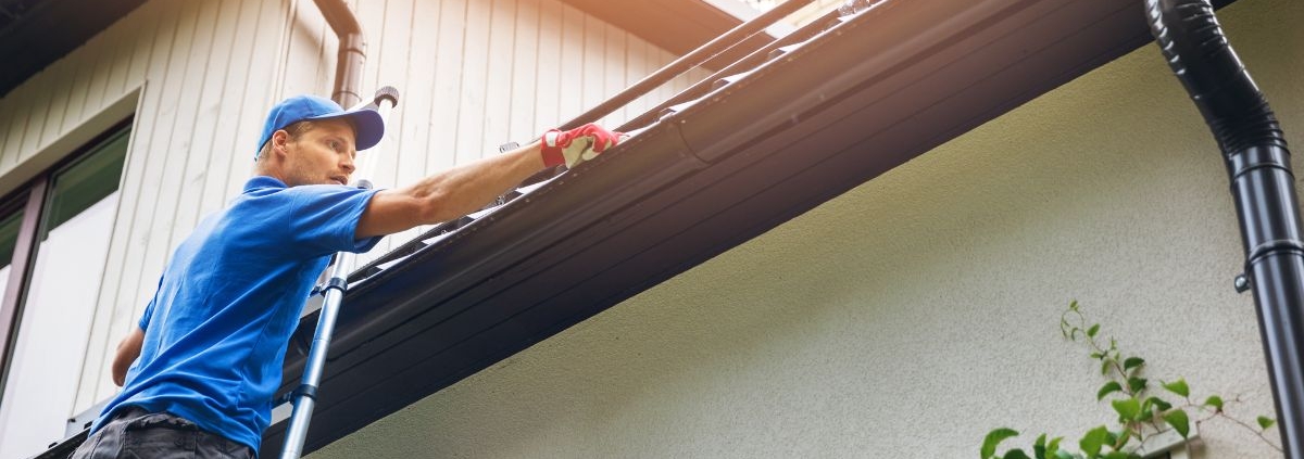 man installing gutters on a roof - Rain Master gutter installation