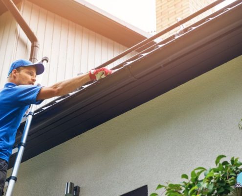 man installing gutters on a roof - Rain Master gutter installation