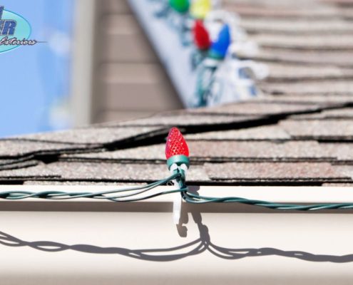 close up of multi colored holiday lights on gutters - Rain Master hanging Christmas lights