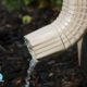 tan colored downspout with water coming out - Rain Master Gutters for Drainage