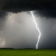 empty grass field with a thunderstorm coming through - Rain Master Seamless Gutters