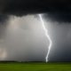 empty grass field with a thunderstorm coming through - Rain Master Seamless Gutters