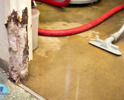 homeowner cleaning up water in their basement - Rain Master overflowing gutters