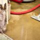 homeowner cleaning up water in their basement - Rain Master overflowing gutters